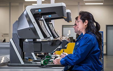 Woman in factory looking through DRV-Z1 3D digital viewer with zoom